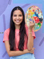 Sports artist Lili Cantero holding a paint-covered palette
