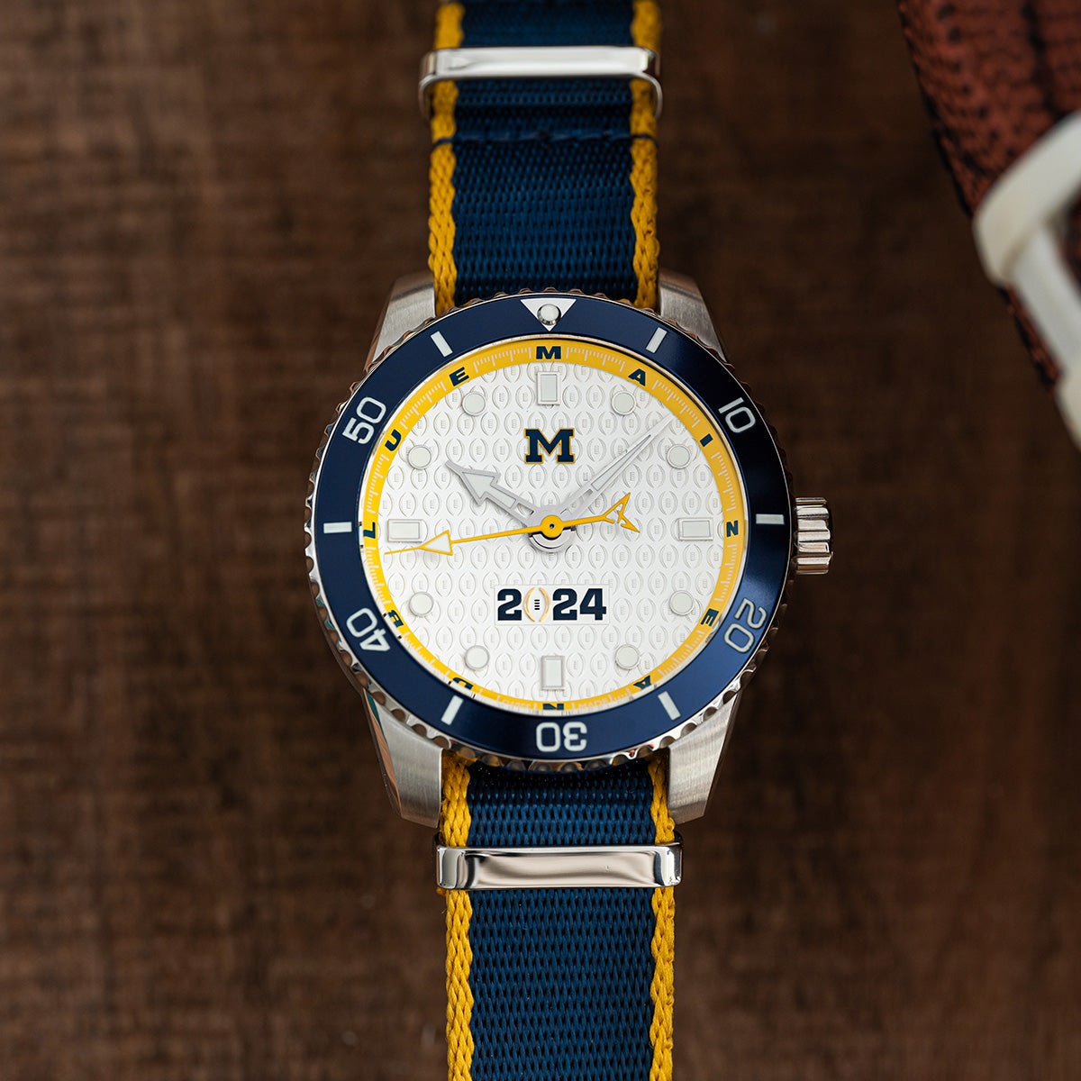 CFP 2024 Michigan Wolverines Odysseus swiss made automatic watch. NATO strap on table.