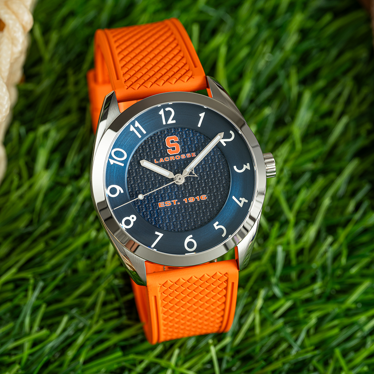 Syracuse lacrosse Swiss made automatic watch. Front view on grass with color-matched rubber strap.